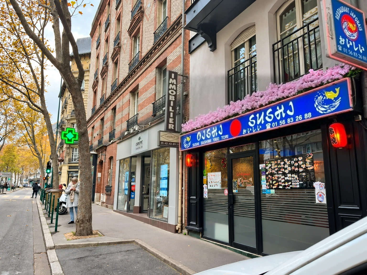 The blue shopfront of Oishi Sushi, 55 Rue du Bournard, with pink flowers and red lanterns.